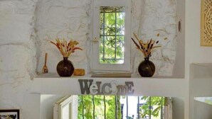 A reception area with a 'Welcome' sign, a door with a metal gate, and two vases with dried plants. - L'Eden - Unique and Charming - Suquet (Cannes)