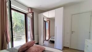 A bedroom with a bed, a wardrobe, a dresser, and a sliding glass door leading to a balcony. - FRANK'S COTTAGE - COUNTRY HOUSE: ENTIRE VILLA FOR EXCLUSIVE USE  (Abruzzo)