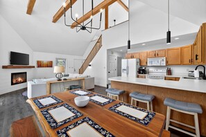 Une cuisine moderne avec des meubles en bois, un plan de travail blanc et une cuisinière intégrée.