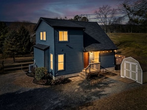 A two-story house with a front porch, a garage, and a fenced yard.