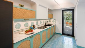 A kitchen with a sink, countertop, and cabinets. - Estate4home - Villa Nerea (Massa Lubrense)