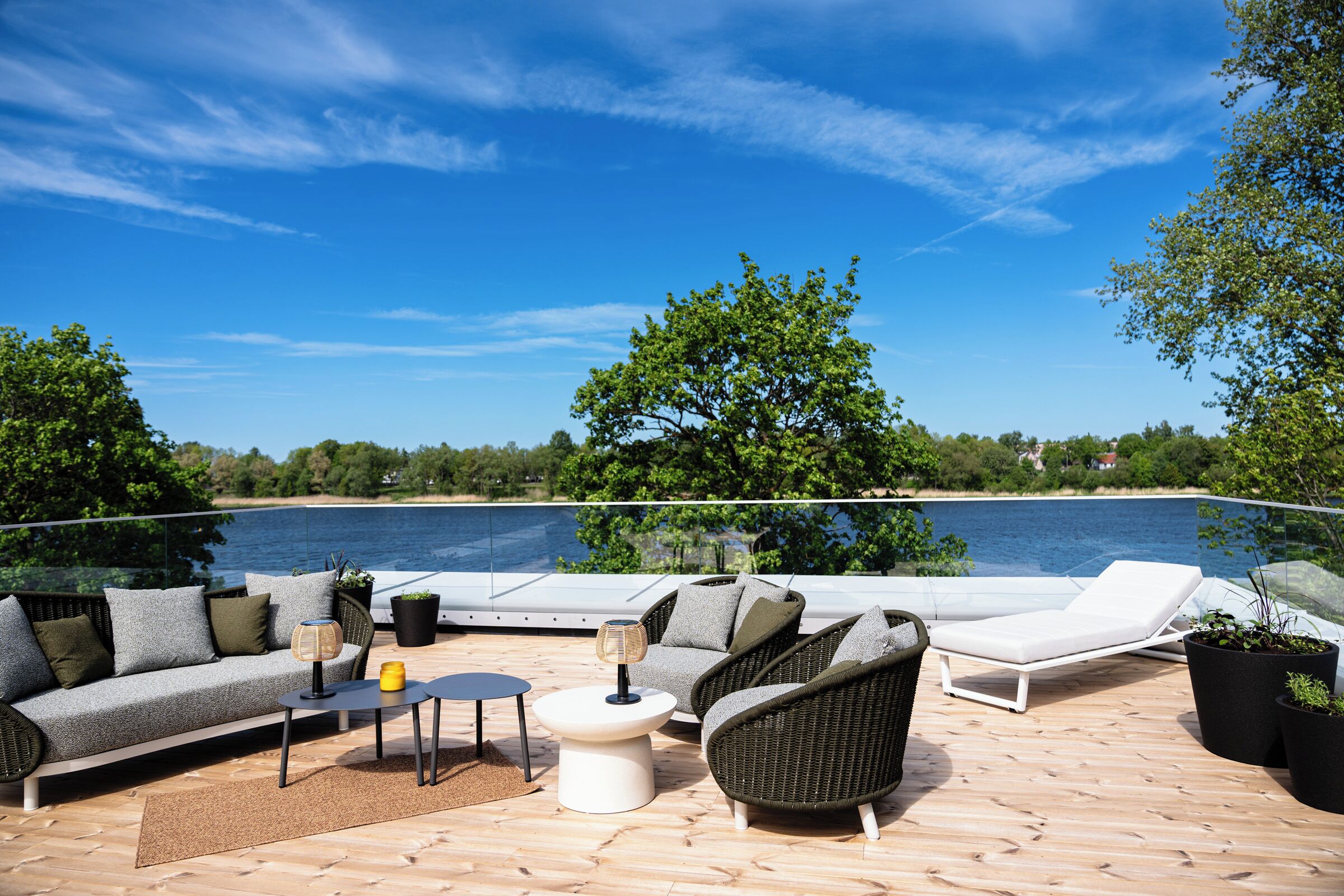 Une terrasse dotée de mobilier d’extérieur, d’une piscine et offrant une vue sur un plan d’eau.