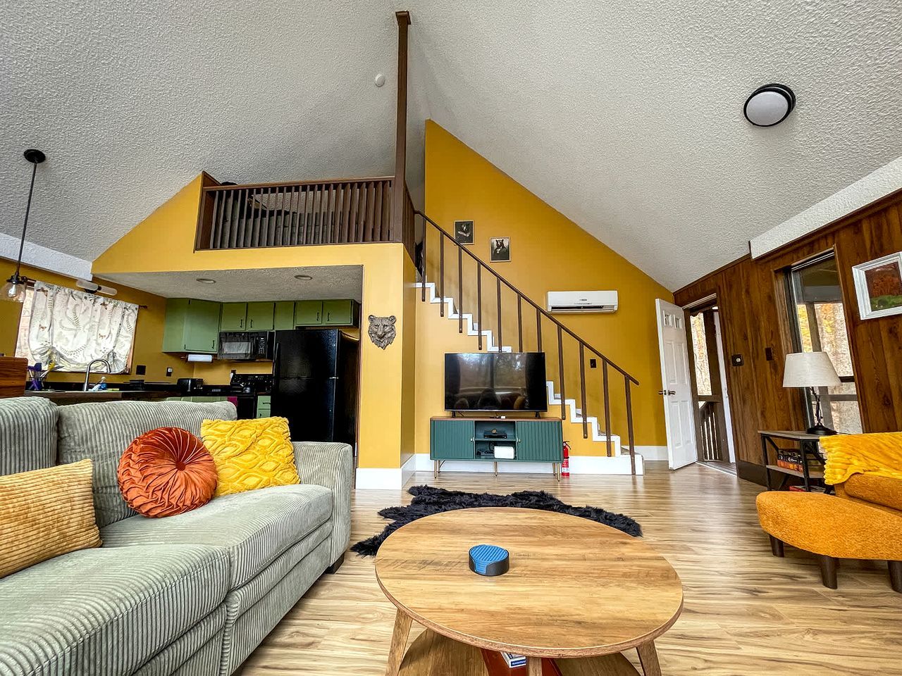 A living room with a sofa, coffee table, and a television.