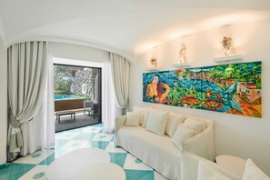 A modern living room with a sofa, a painting, and a view of a swimming pool. - Villa Nerea (Nerano)