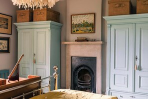 A room with a fireplace, a bed, a desk, and two wardrobes. - Lavish Farmhouse with Lake access, Gardens & Pool Table (Oakhill)