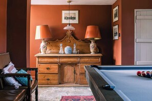 A room with a wooden dresser, two lamps, a framed picture, and a pool table. - Lavish Farmhouse with Lake access, Gardens & Pool Table (Oakhill)