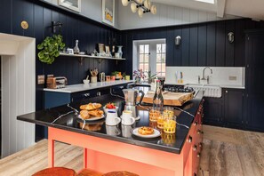 Une cuisine avec un îlot central, une machine à café et un grille-pain.