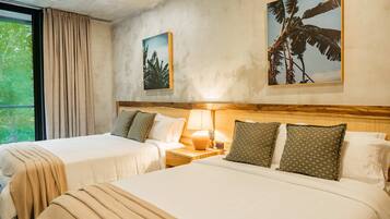 Quarto de hotel com duas camas, uma mesa de cabeceira com abajur e duas imagens emolduradas na parede.