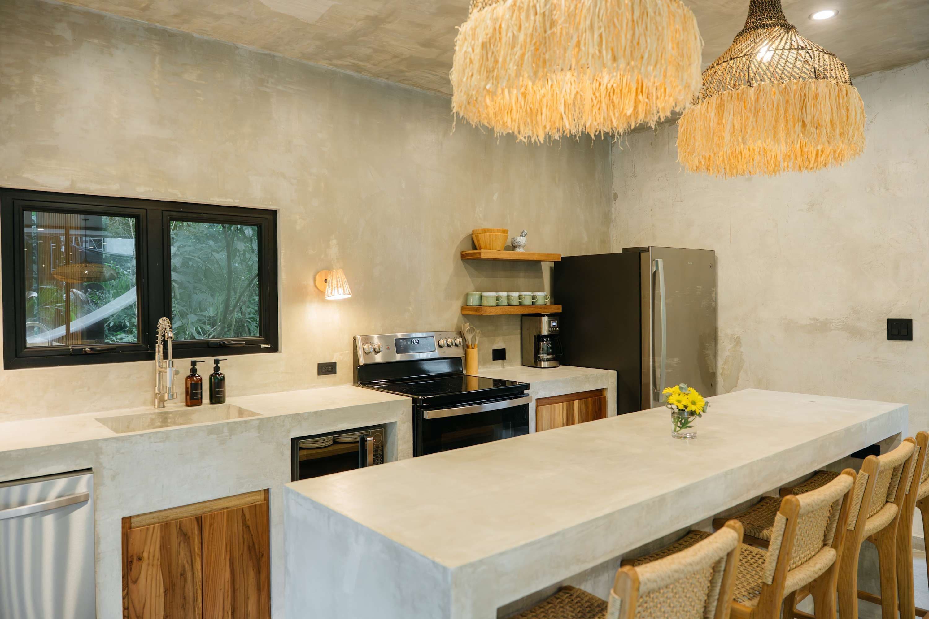 Uma cozinha moderna com uma ilha grande, eletrodomésticos embutidos e um lustre.