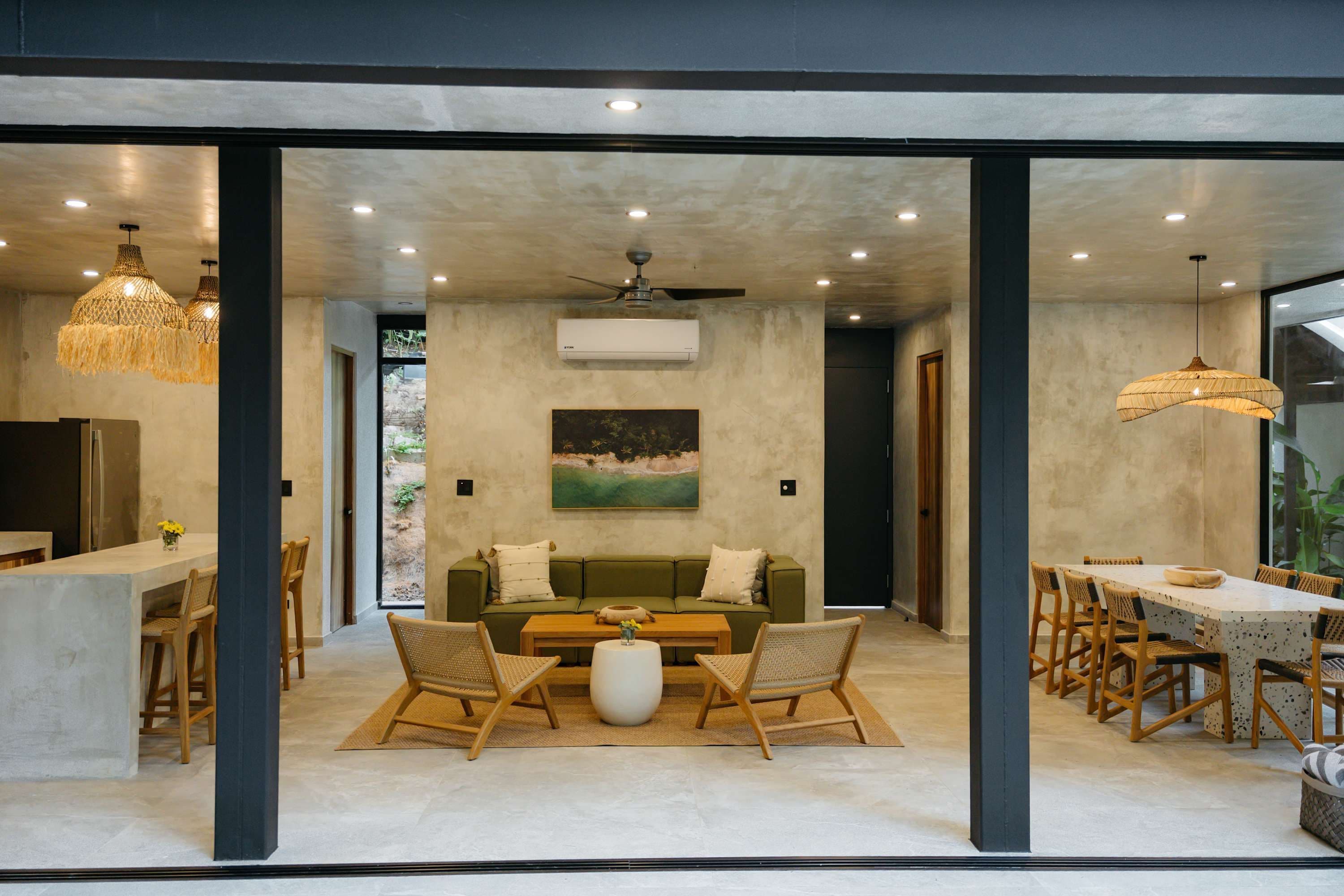 Um interior moderno com uma área de jantar, um conjunto de sofás e uma pintura na parede.