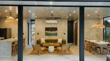 Um interior moderno com uma área de jantar, um conjunto de sofás e uma pintura na parede.