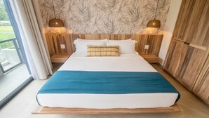 Ein Schlafzimmer mit einem großen Bett, einem Holzkopfende und Blick ins Freie.