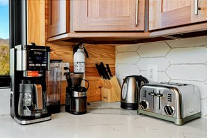 Eine Küche mit Kaffeemaschine, Mixer, Wasserkocher und Toaster.