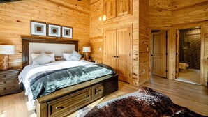 Ein Holzinterieur mit einem Bett, Nachttischen und einem Deckenventilator.