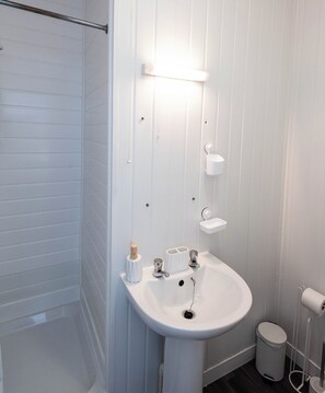 Ein Badezimmer mit Waschbecken, Toilette und Duschbereich.