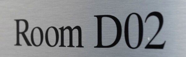 Ein Schild mit der Aufschrift 'Room D02', das eine bestimmte Zimmernummer kennzeichnet.