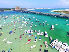 A marina with numerous boats docked, a pier extending into the water, and a distant cityscape. - Coastal Cool - Relaxing Crystal Beach Getaway with Balcony & Pool (Destin)