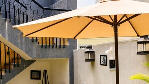 Un patio al aire libre con mesa y sillas, una escalera y plantas en macetas.