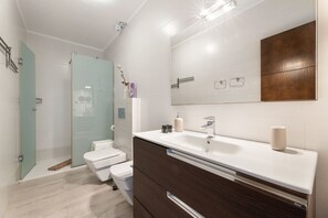A modern bathroom with a shower, toilet, and vanity. - Casa Foti Puerto del Carmen - Media estancia (Puerto del Carmen)
