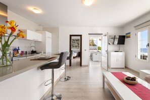 A modern kitchen with a bar area, a dining space, and a view of the outdoors. - Casa Foti Puerto del Carmen - Media estancia (Puerto del Carmen)