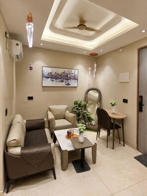 Un salon moderne comprenant un canapé, un fauteuil, une table basse et un coin repas avec une chaise et une table.