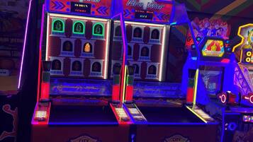 Een felverlichte speelautomaat met een brandweerthema, inclusief neonverlichting en een scorebord.