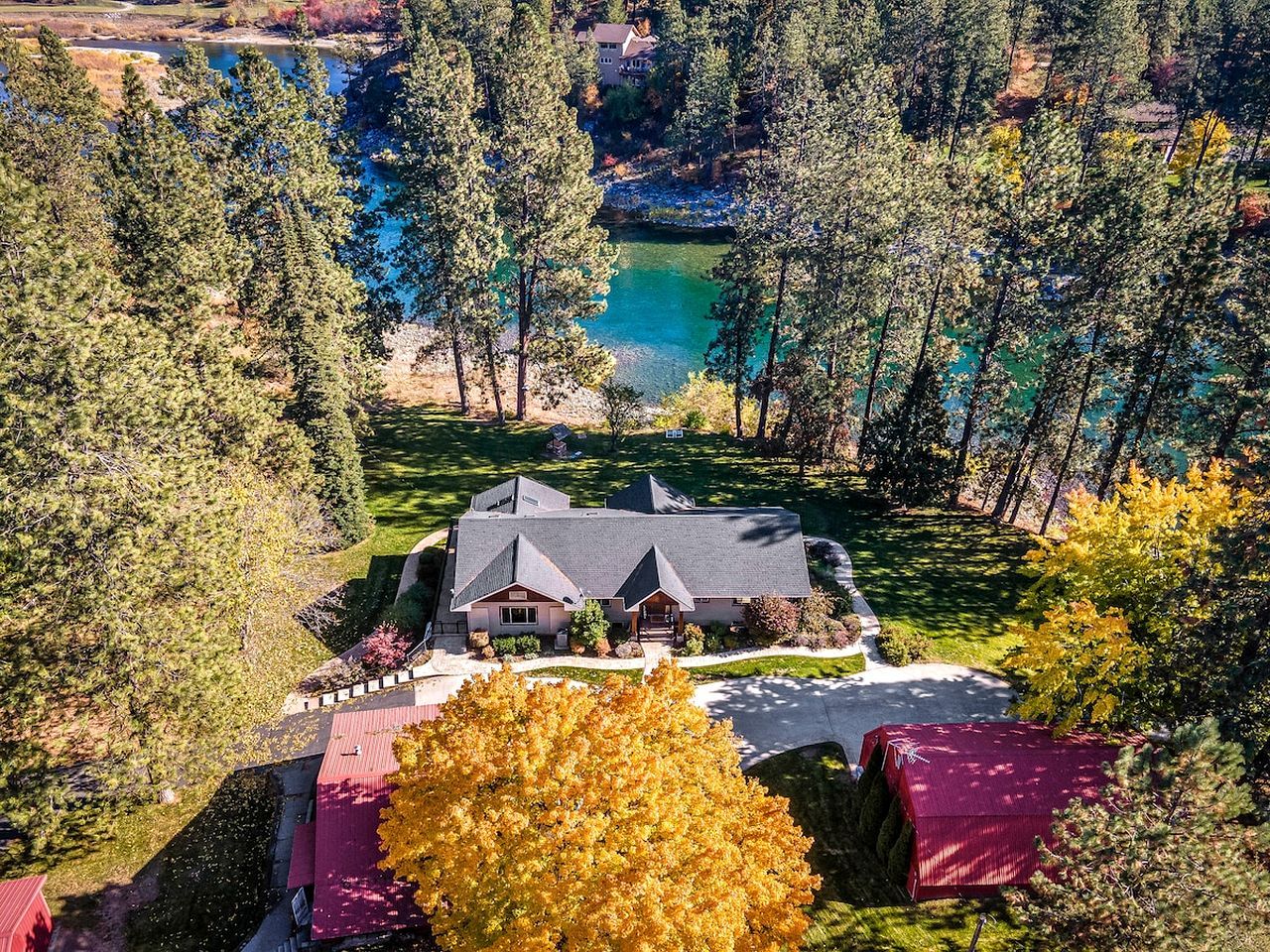A house surrounded by trees and a lake.