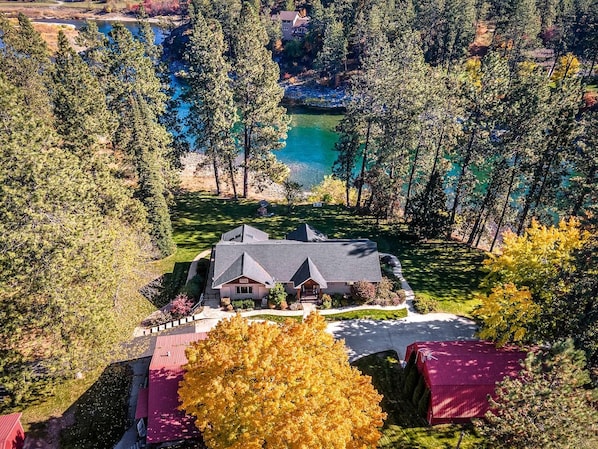 Ett hus omgivet av träd och en sjö.