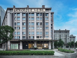 A multi-story building with a service apartment labeled 'POLTON SERVICE APARTMENT' on the ground floor. - Poltton International Apartment Hotel (Wuhan High-Speed Rail Station West Square Happy Valley) (Wuhan)