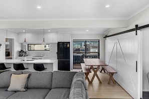 A modern apartment with a kitchen, dining area, and a balcony.