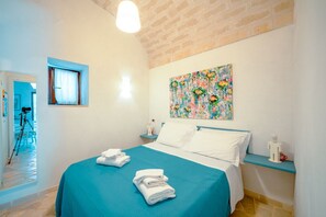 Ein Hotelzimmer mit einem Bett, einem Bild, einem Fenster und einem Nachttisch.