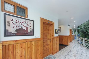 Un pasillo con paneles de madera, una obra enmarcada y una puerta con un número.