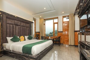 A hotel room with a large bed, a desk, and a view of the outdoors.