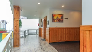 A corridor with wooden paneling, a painting on the wall, and a sign indicating the 4th floor. - BR Resort (Dharamshala)