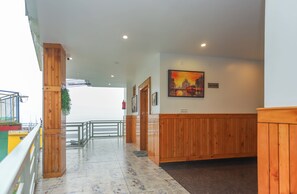 Um corredor com painéis de madeira, uma pintura na parede e uma placa indicando o quarto andar.