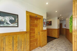 A hallway with wooden paneling, a framed tiger artwork, and a door labeled '201'.