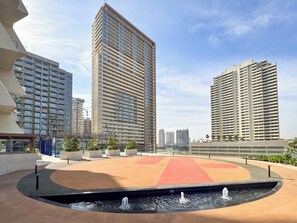 A modern urban plaza with a central water feature, surrounded by high-rise residential buildings. - PVH - Binghatti Royale 1BR Private Pool (Dubai)