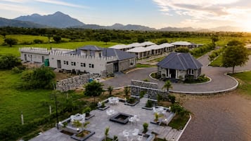 A resort with multiple buildings, outdoor seating areas, and a mountainous backdrop.
