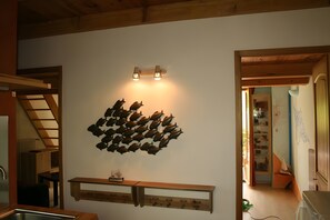 A room with a wall-mounted shelf, a ceiling with wooden beams, and a doorway leading to another room. - Holiday Home 'Bergerie Des Estelles' with Mountain View, Wi-Fi and Air Conditioning (Auriol)