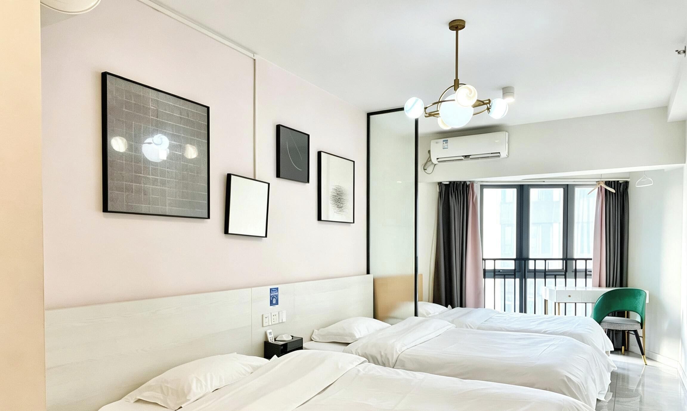 Habitación de hotel con dos camas, un ventanal grande y una obra de arte en la pared.