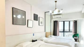 Habitación de hotel con dos camas, un ventanal grande y una obra de arte en la pared.