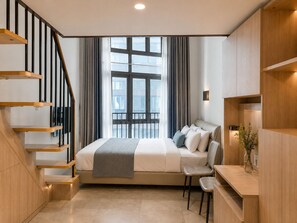 A modern bedroom with a built-in bed, a desk, a chair, a staircase, and a large window.
