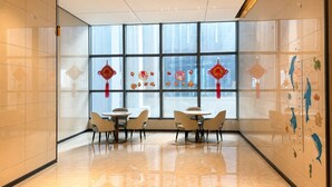A modern interior with large windows, a dining area with round tables and chairs, and decorative elements on the walls. -  Nestory Residence - Foshan Lecong Furniture Market  (Foshan)