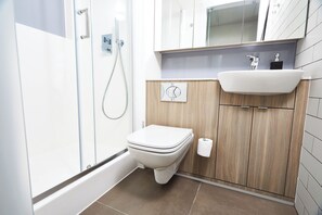 A modern bathroom with a toilet, shower, and sink. - Portswood House (Southampton)
