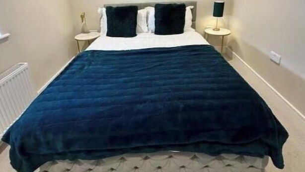Ein Schlafzimmer mit einem Bett, Nachttischlampen und einem Heizkörper.