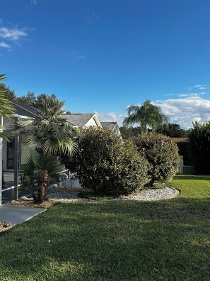 A residential area with a house, a lawn, and a palm tree. - Luxury 3BR/2BA Home in The Villages w/golf cart. Pet Friendly, Near golf course (The Villages)