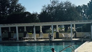 Ein Schwimmbad mit überdachtem Bereich und Liegestühlen.