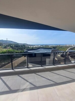 Un balcón con vista a un paisaje urbano y una masa de agua.