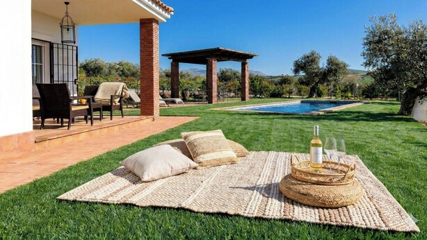 Ein Garten mit Schwimmbad, Gartenmöbeln und einer Pergola.