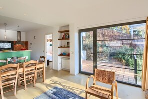 A modern kitchen with a built-in oven and a dining area with wooden chairs and a blue rug. - Villa 'Sa Tuna' with Sea View, Wi-Fi and Air Conditioning (Begur)